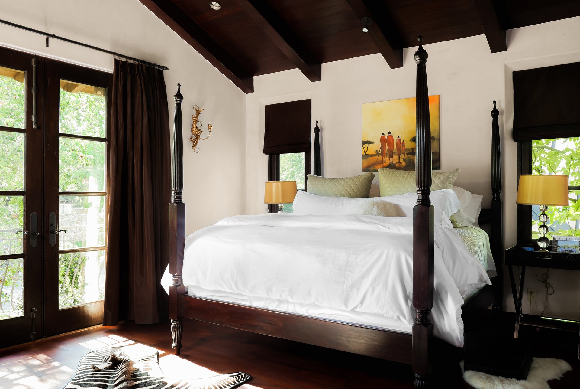Bedroom with four-poster bed, beamed ceiling, and French doors
